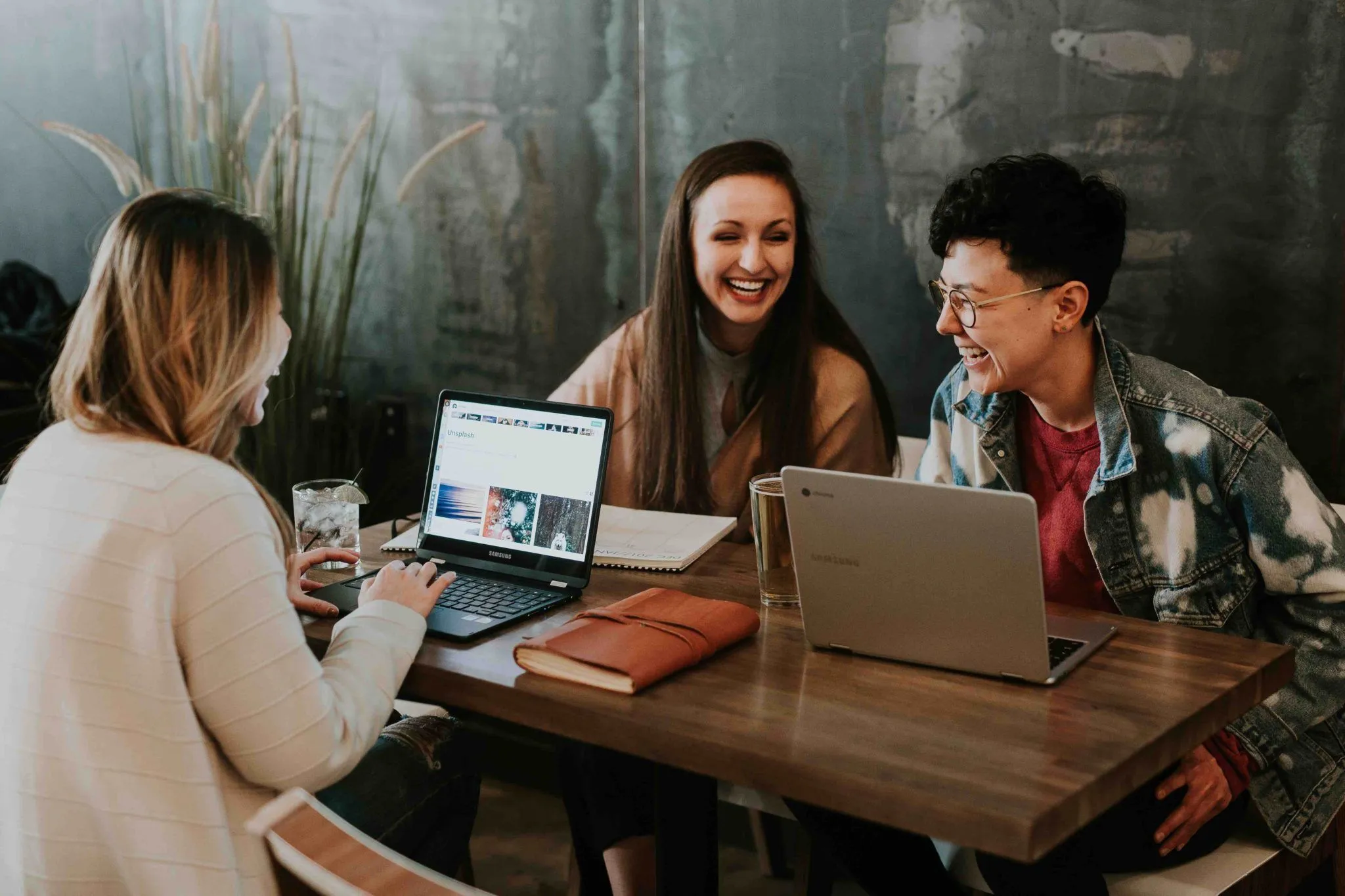 three people working on laptops and collaborating