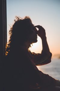 man holding head by window stop binge drinking