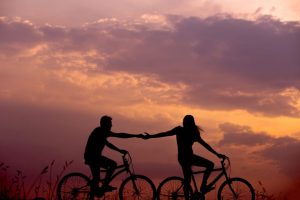children of alcoholics holding hands on bicycles