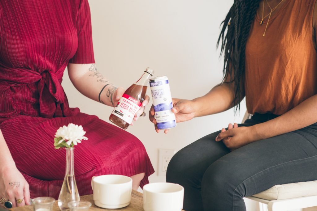 two people raising nonalcoholic drinks during sober october