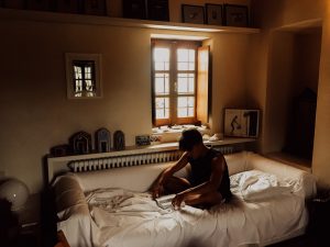 young man sitting on bed with hangover anxiety