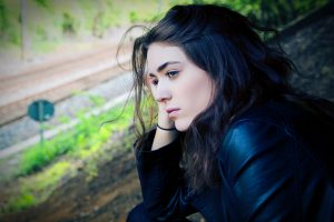 womanlooking pensively over railroad tracks, alcohol cravings