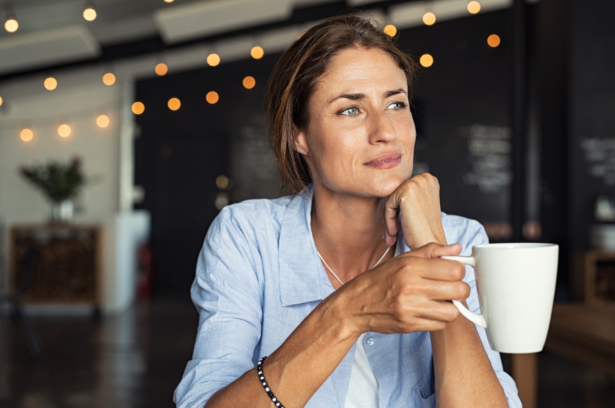 insurance coverage for alcohol rehab woman sitting with coffee