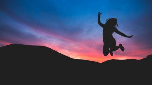 how to get sober from alcohol woman jumping at sunset