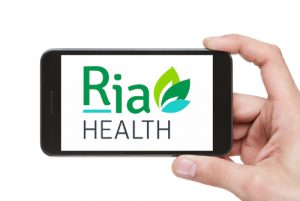 hand holding phone with the Ria Health App