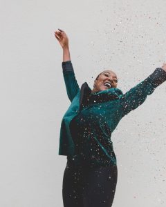 woman in green with confetti celebrating recovery