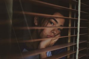 drinking more in quarantine woman looking out window