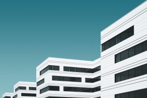 white buildings on blue background, rehab vs. online telehealth
