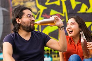 friends drinking and laughing how to stay sober when your spouse drinks