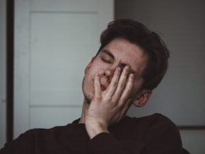 young man with headache, hangover pills