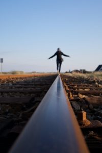 woman balanced on rail, dealing with drinking triggers