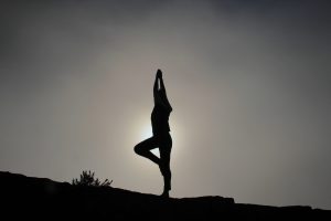 person doing yoga at dusk, dealing with triggers in recovery