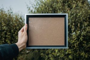 person holding blank picture frame