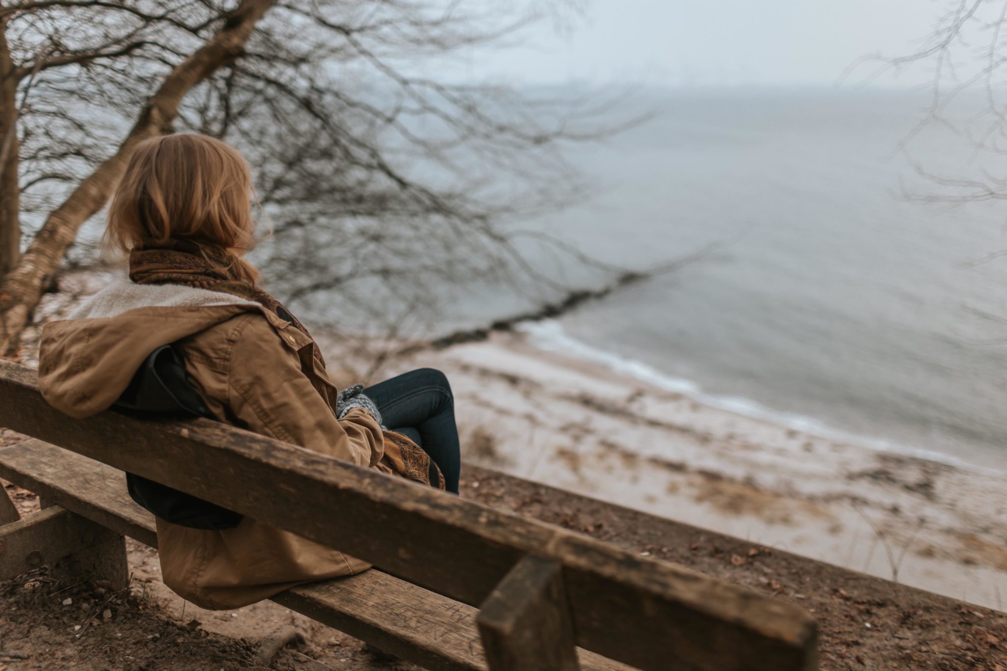 woman sitting on bench, depressed after drinking alcohol