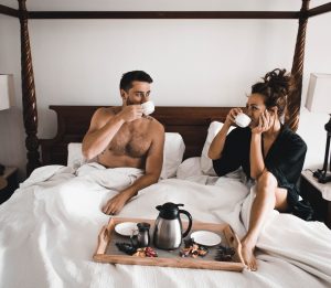 couple drinking coffee in bed