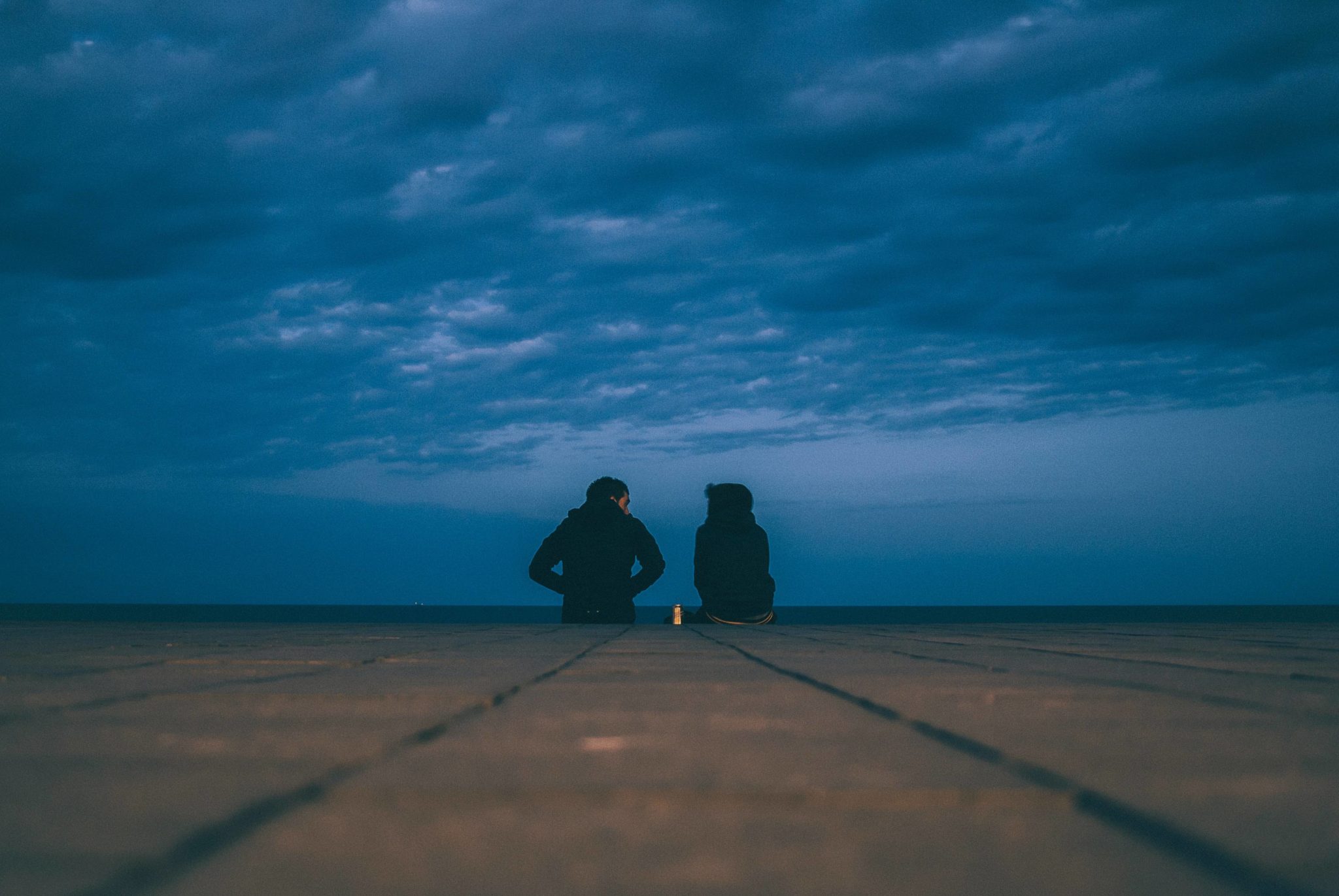 couple sitting on dock, talk to your partner about your addiction