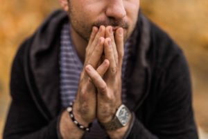 man sitting with folded hands treating anxiety and alcohol addiction