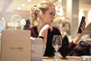 woman looking at phone with shopping bags