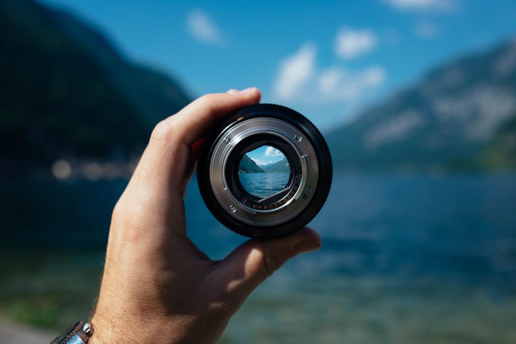 hand holding lens, bringing landscape into focus