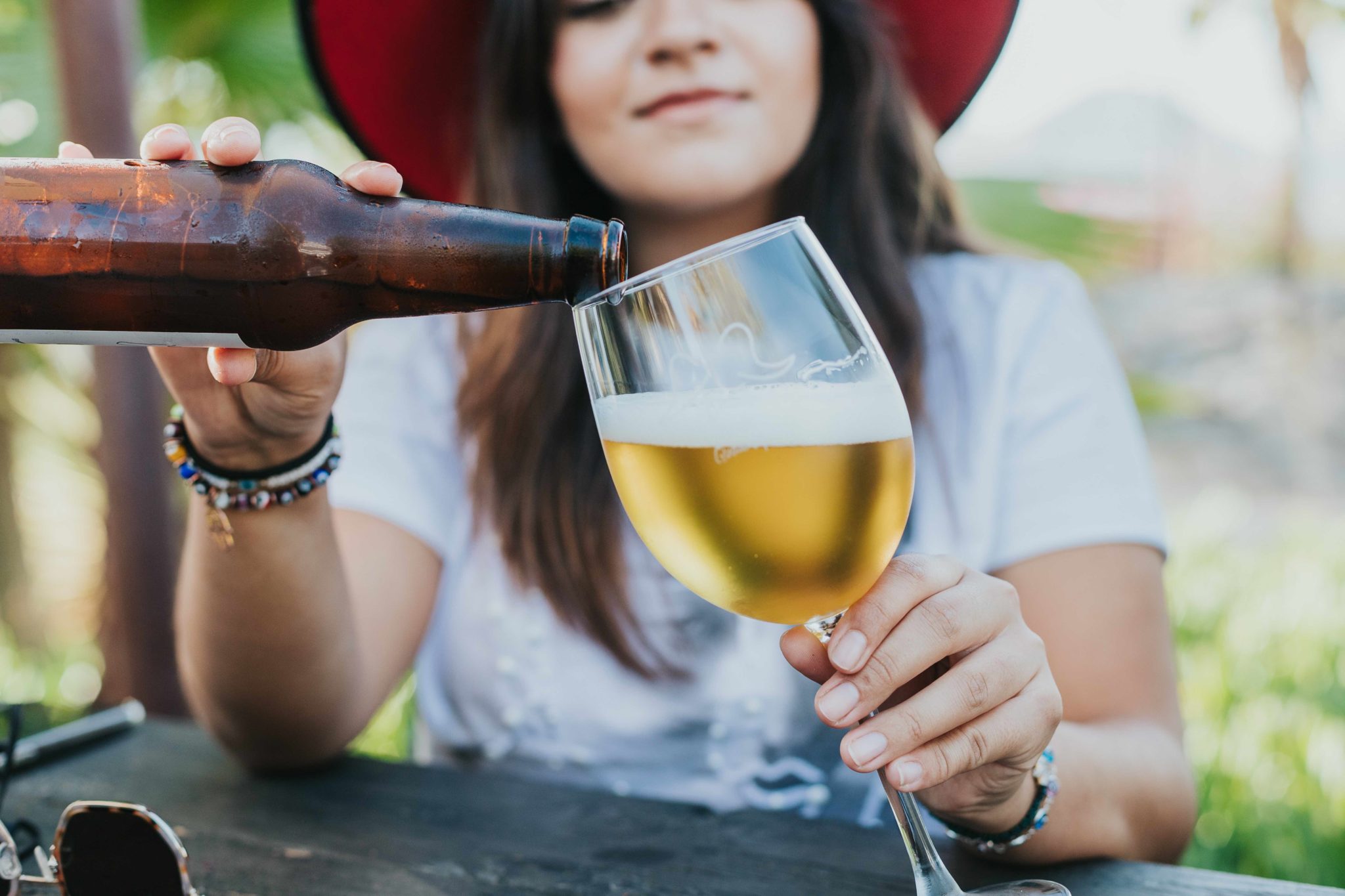 young woman filling glass with beer