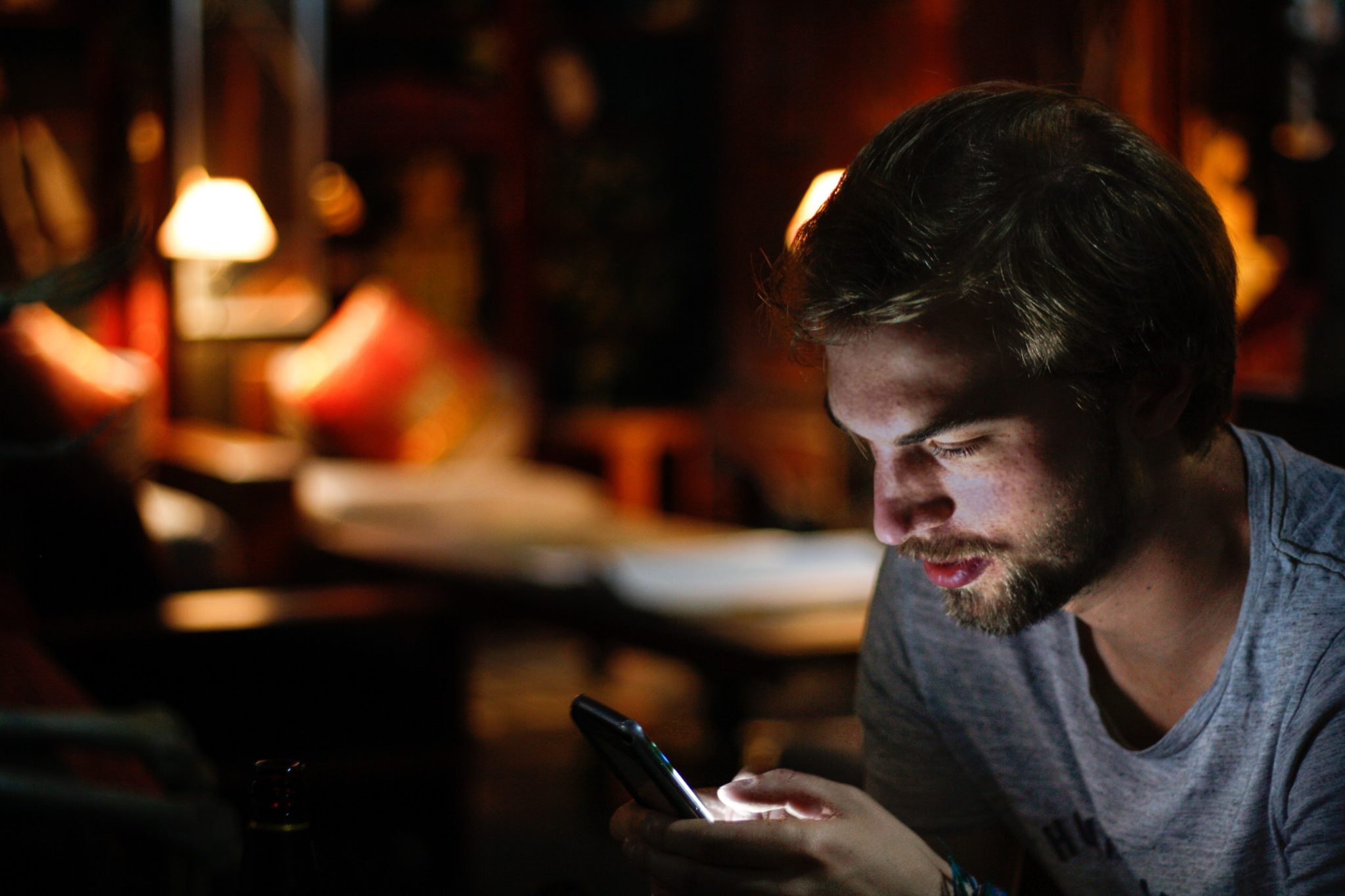 man sending a text in a restaurant at night