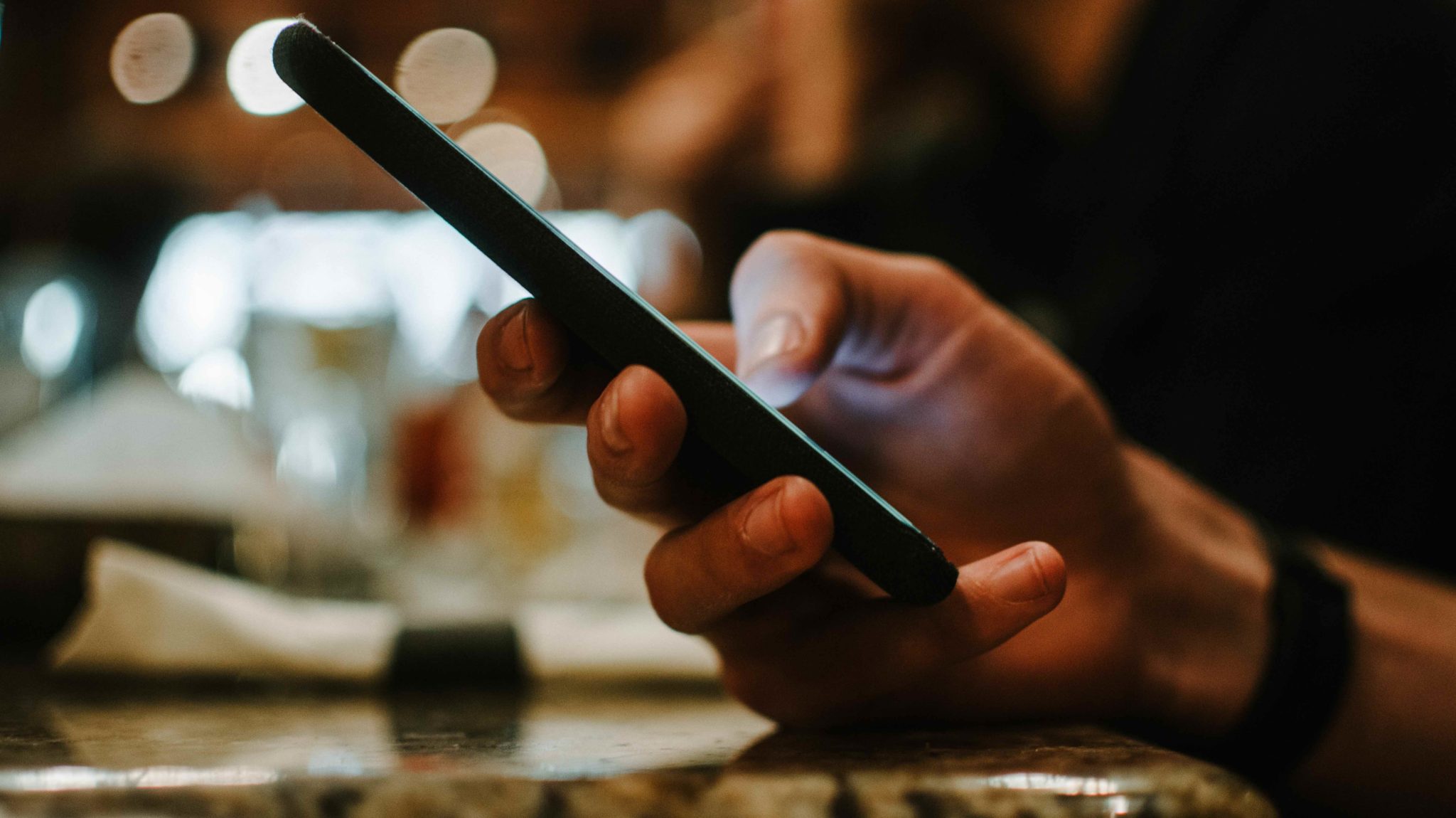 hand holding phone at a bar