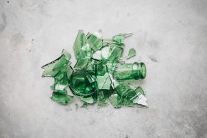broken green glass bottle on concrete