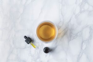 CBD tincture in a glass on a marble table