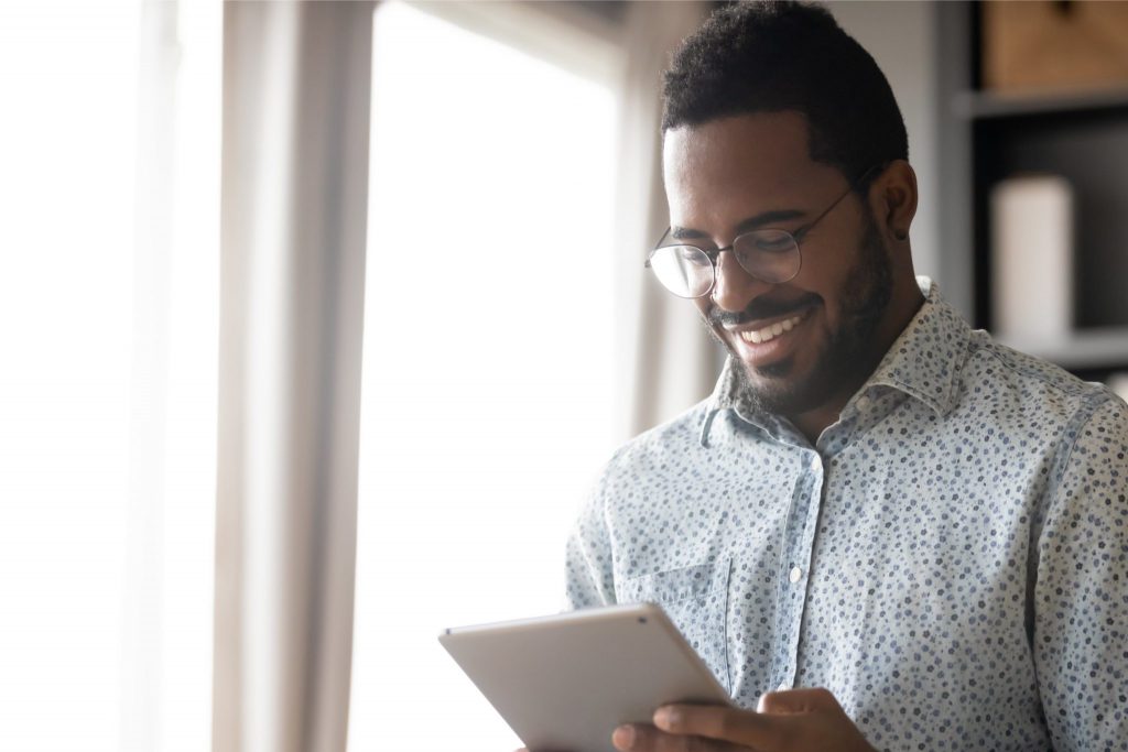 man on tablet standing by the window