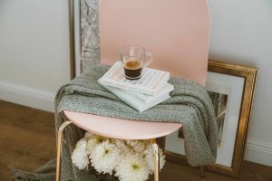 coffee, books, and blanket on chair