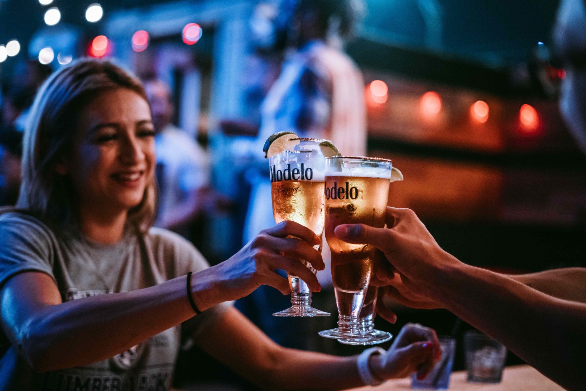 people raising beer glasses at a bar