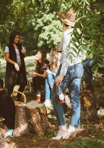 younger women drinking wine in the woods