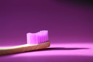 toothbrush with purple bristles on purple background