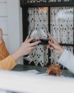 two people clinking wine glasses