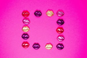 purple, red, and gold colored lips on pink background