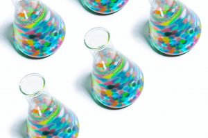 beakers filled with colorful marbles and liquid