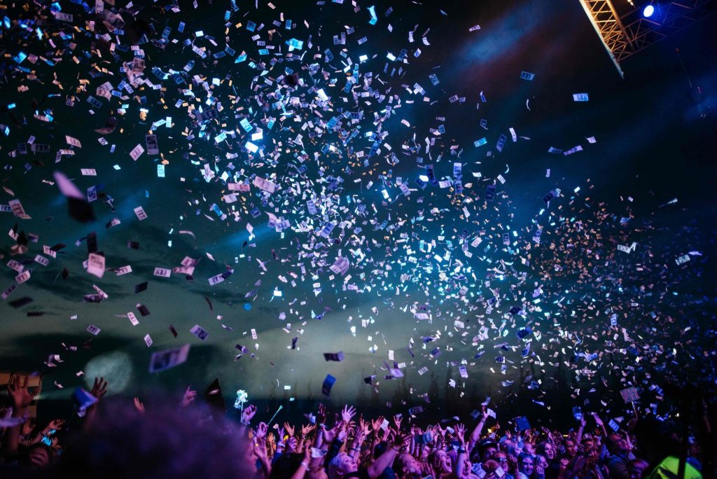 huge crowd at a festival throwing confetti