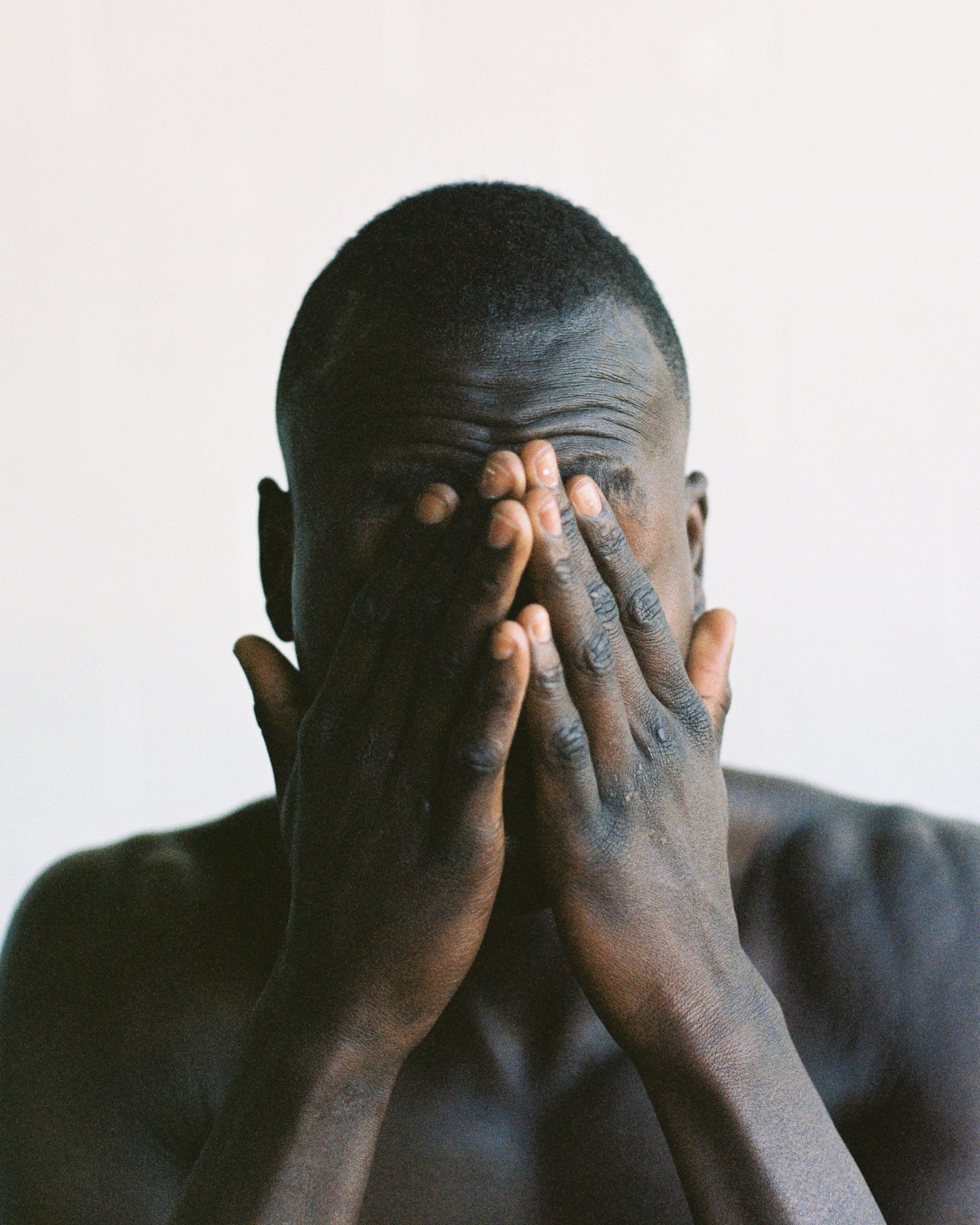 hungover man with his hands over his face