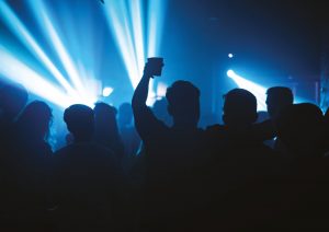 party people holding drinks at nightclub