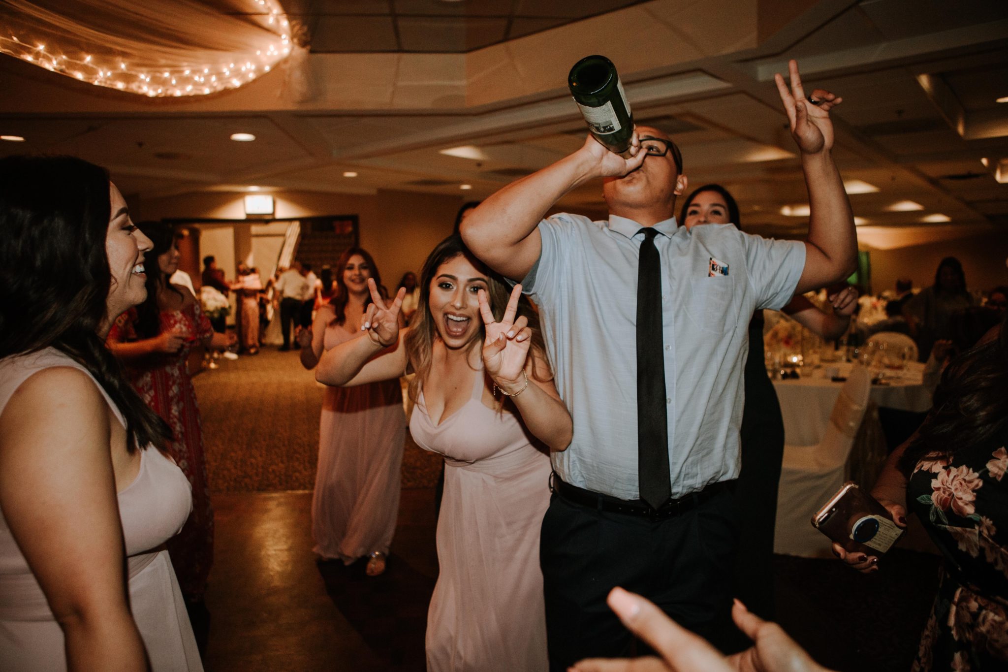 people chugging champagne at a wedding reception