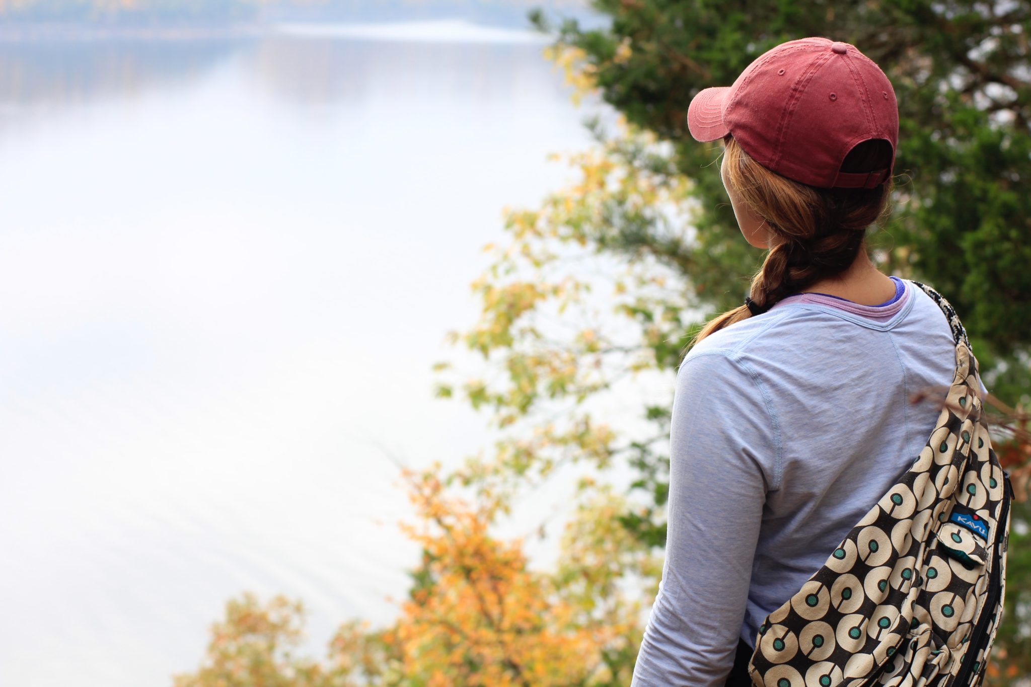 woman with a bag overlooking a river