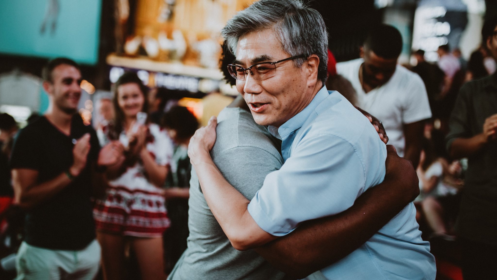 two people embracing at a group meeting