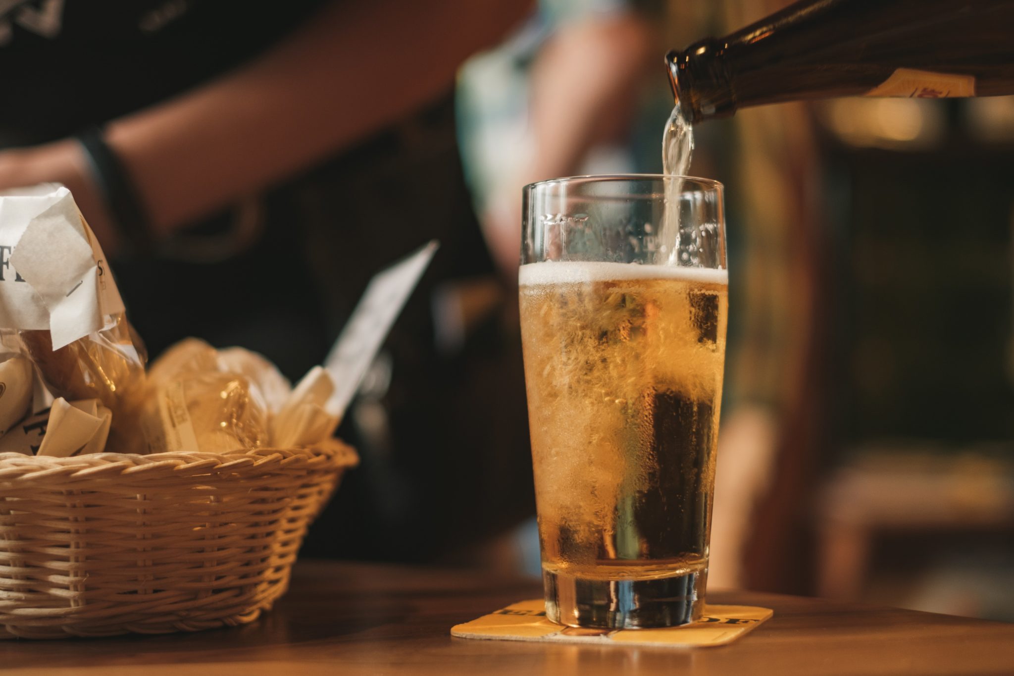 beer in glass next to basket of chips