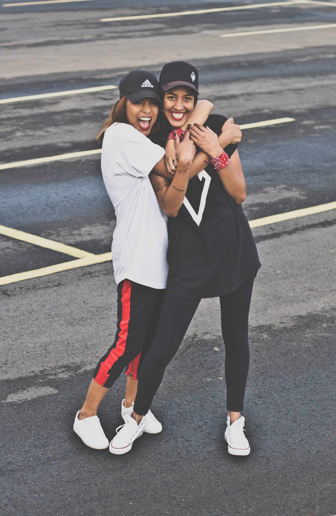 two women hugging and smiling on a city street