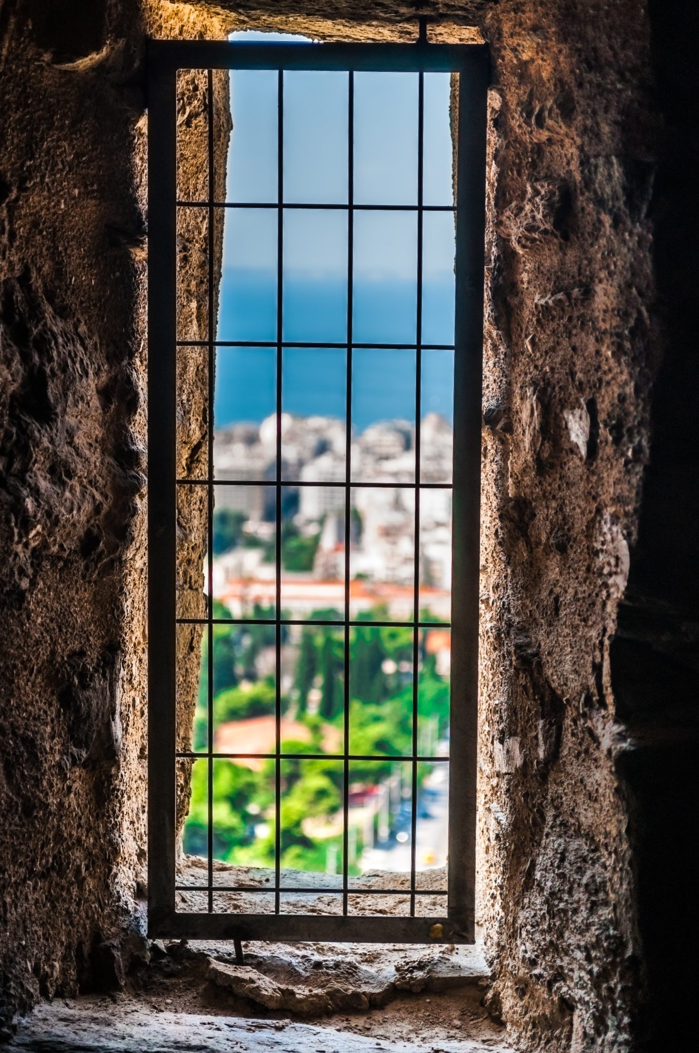 bars over a window overlooking a beautiful town