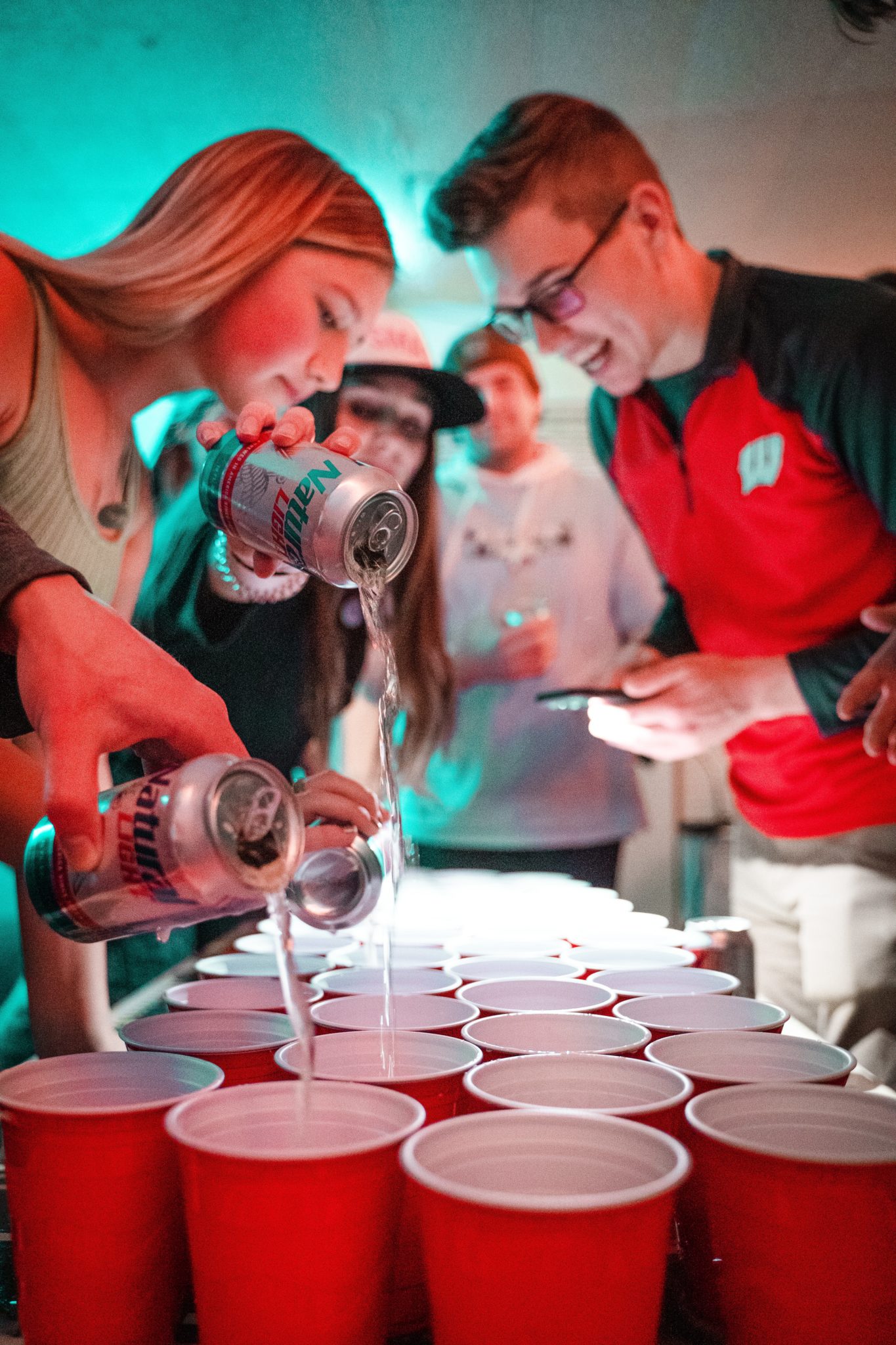 group of friends filling glasses for beer pong