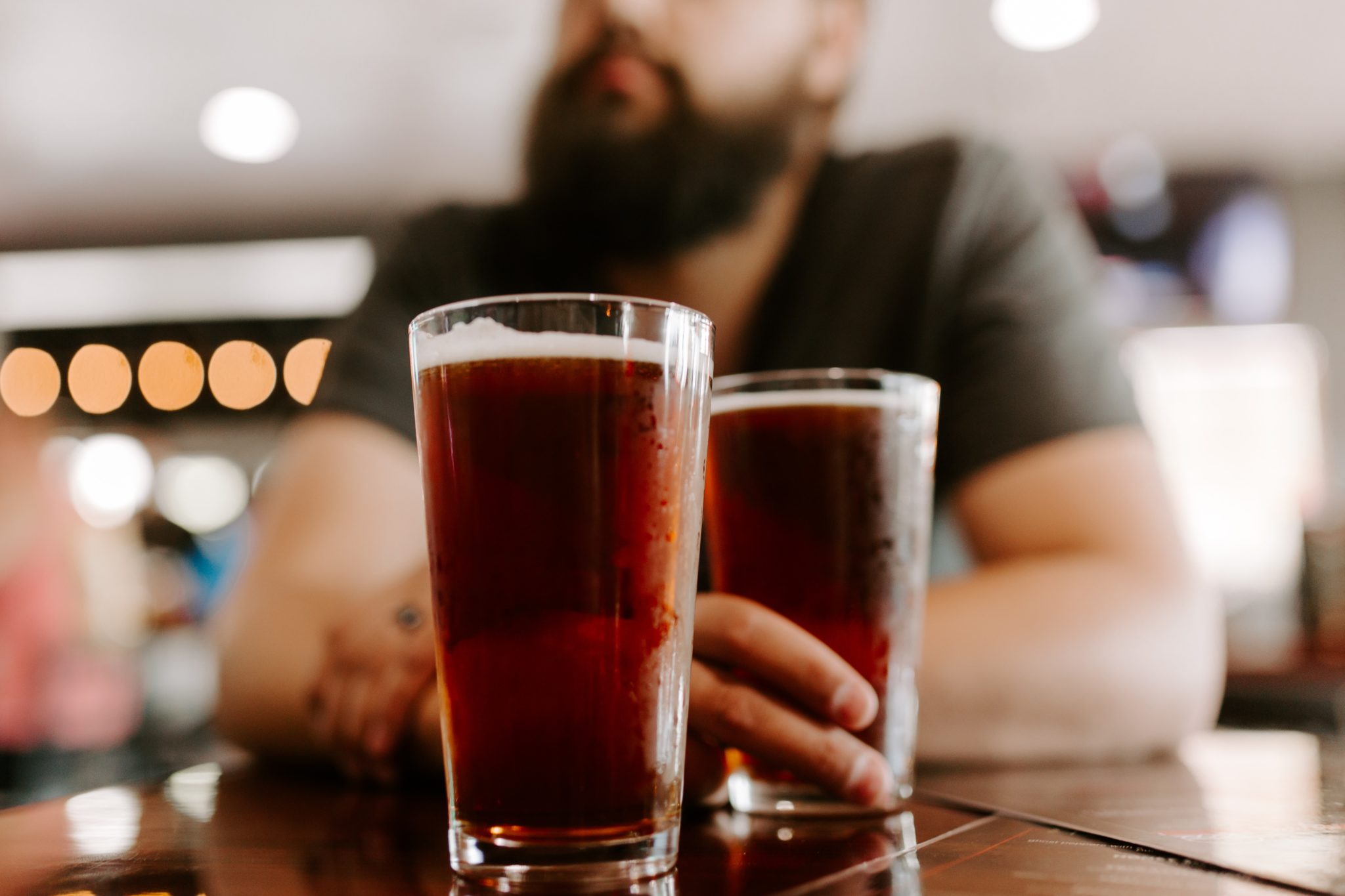 two beers in front of a bearded man