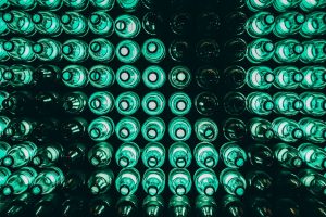 line of illuminated green beer bottles