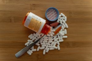 pill bottle and pills with spoon on table