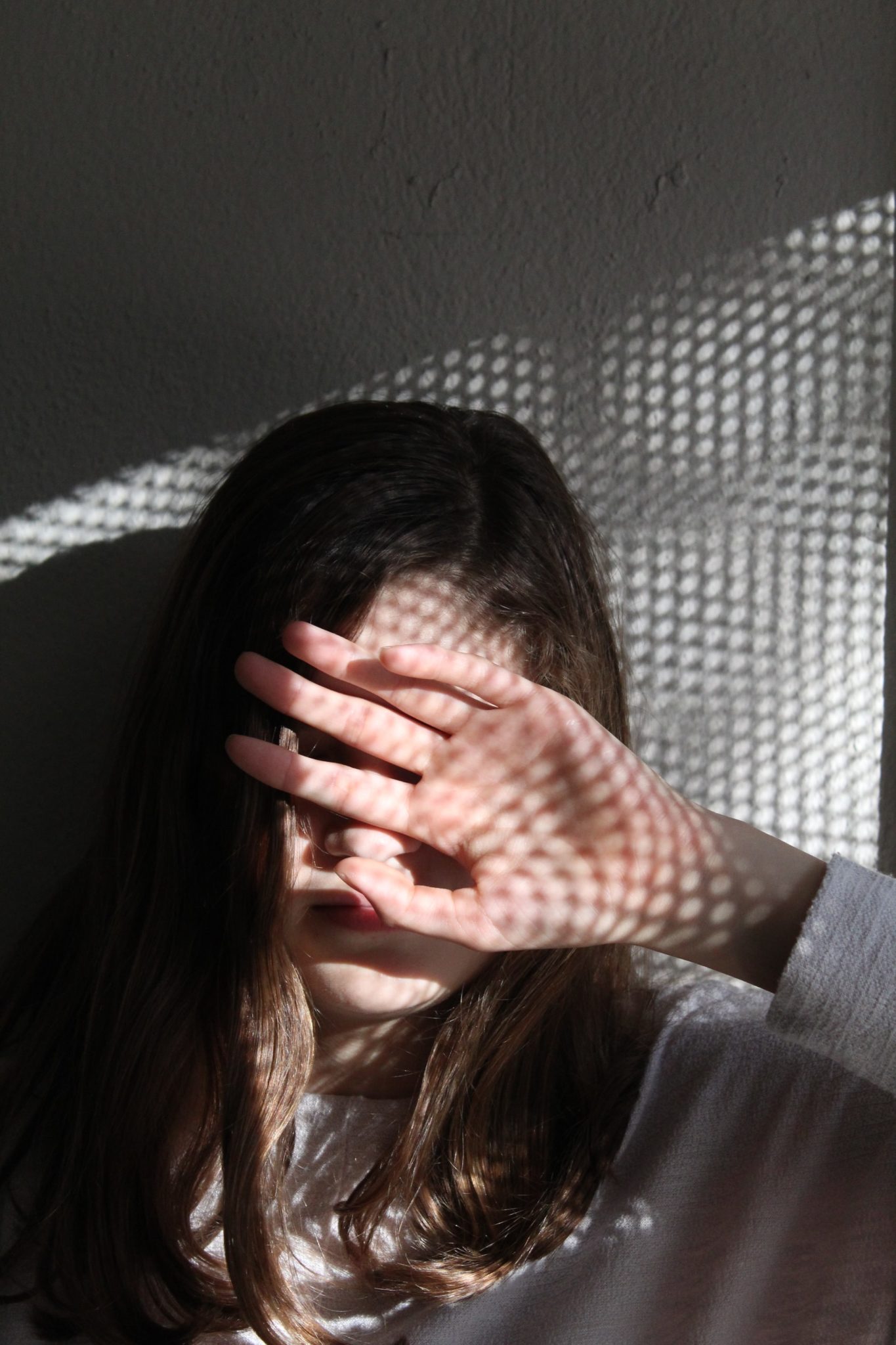 woman covering her face with her hand